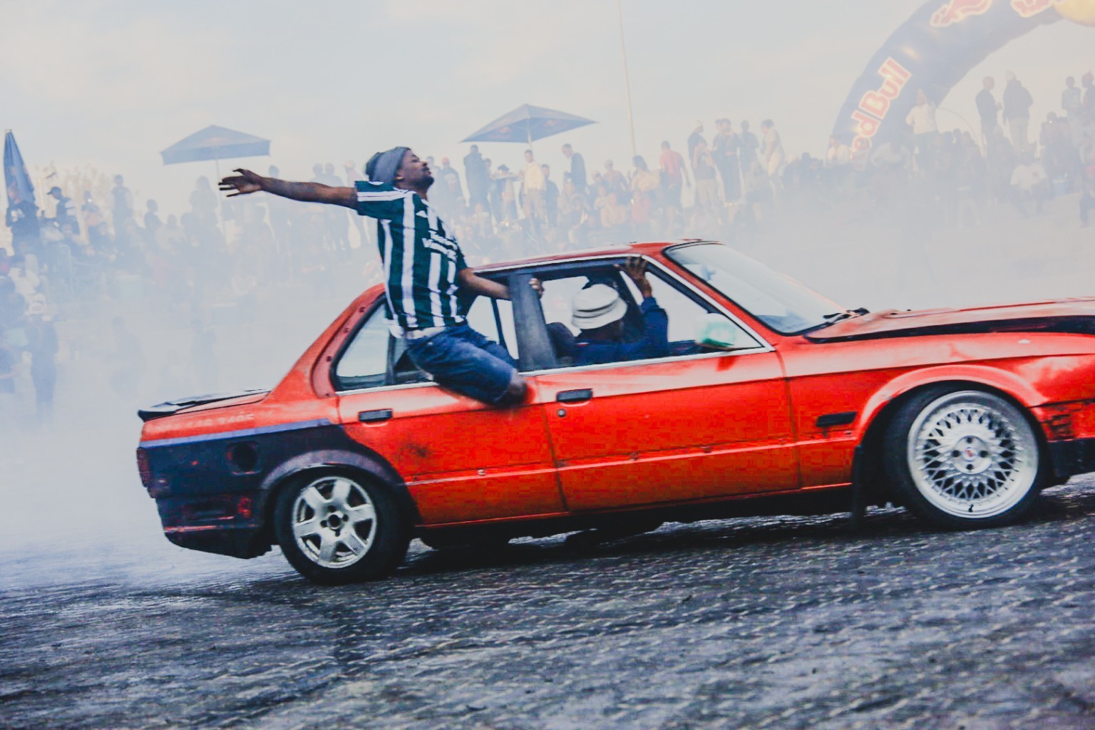 A red spinning car performing in a cloud of smoke