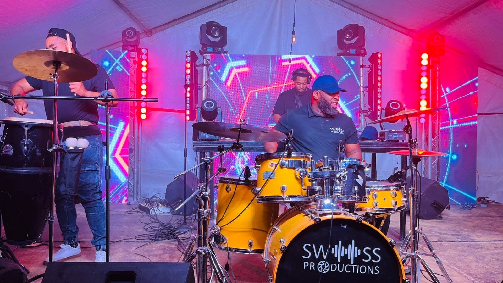 Musicians performing on a stage with colourful lighting